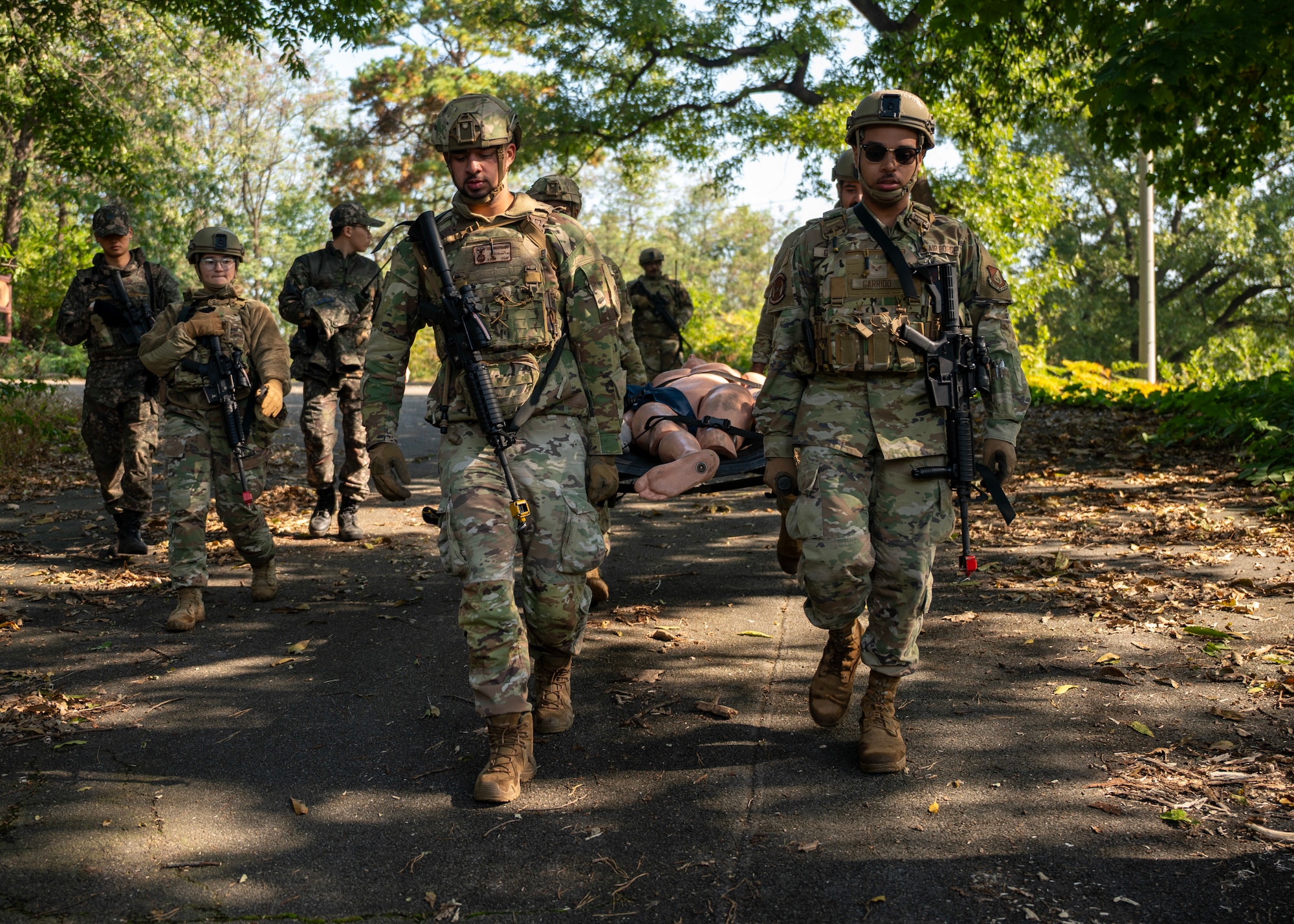 Members of the 51st Security Forces carry a simulated body during a Combat Readiness Course at Osan Air Base, Republic of Korea, Oct. 29, 2025. CRC is a 10-day course which incorporates mounted and dismounted operations, tactical combat casualty care, and buddy drags to better prepare Airmen to defend the base under realistic combat and ground-threat scenarios. (U.S. Air Force photo by Staff Sgt. Sarah Williams)