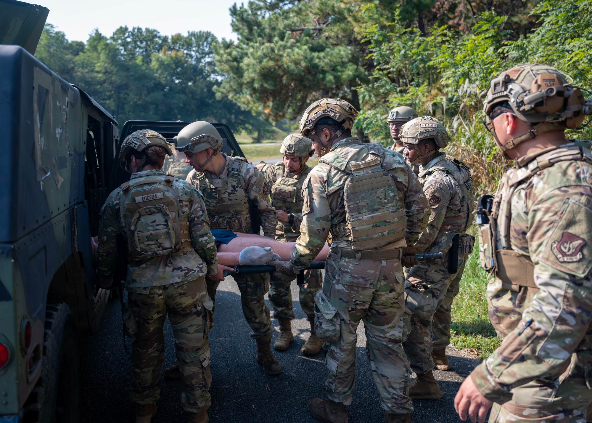 Members of the 51st Security Forces Squadron load a simulated body into a humvee at Osan Air Base, Republic of Korea, Oct. 29, 2025. Combat Readiness Course fostered teamwork, situational awareness, and proficiency in core tasks vital to base defence. (U.S. Air Force photo by Staff Sgt. Sarah Williams)