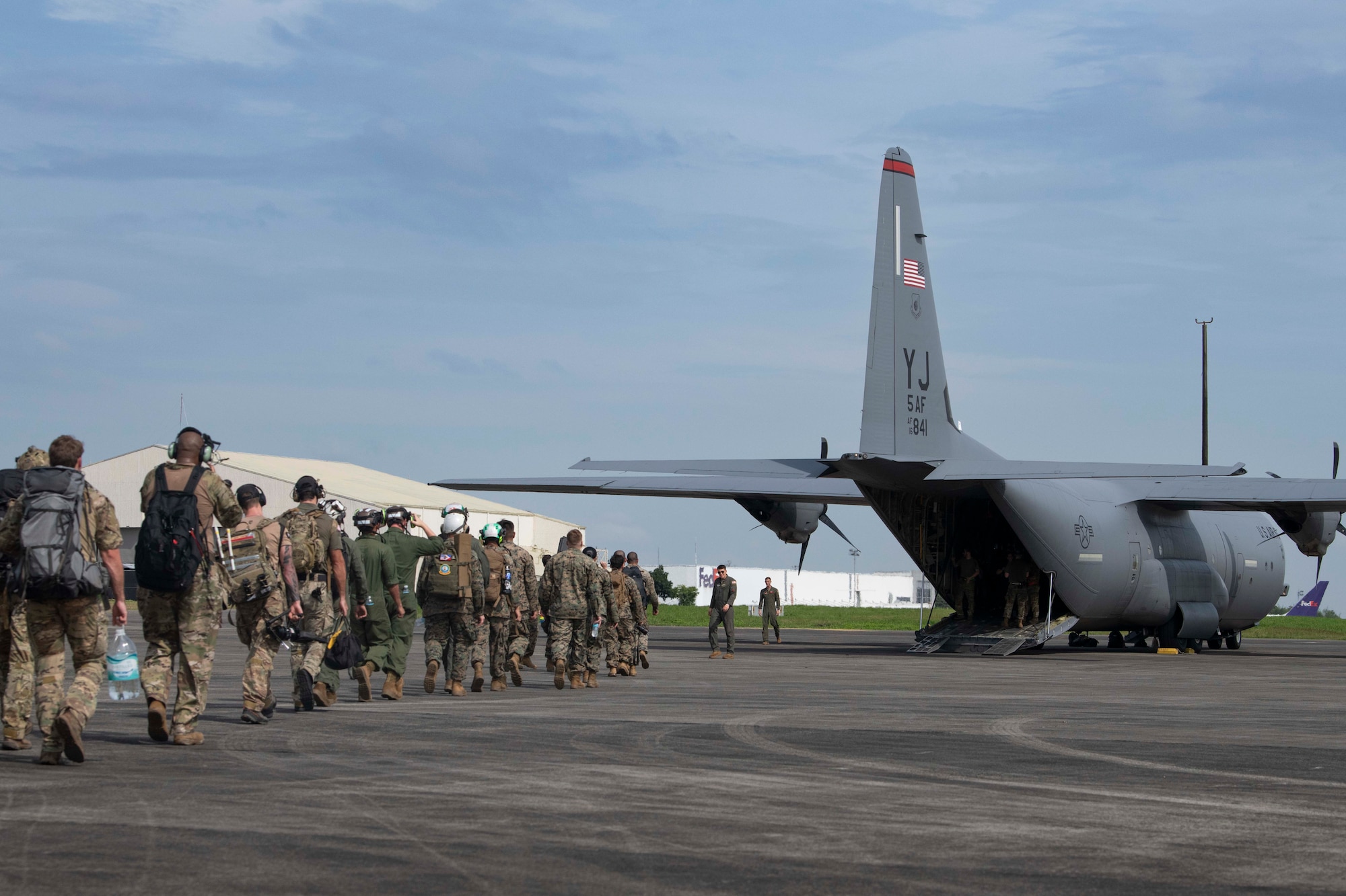 U.S. Air Force Airmen and U.S. Marines prepare to board a C-130J Super Hercules assigned to the 36th Airlift Squadron during a foreign disaster relief operation.