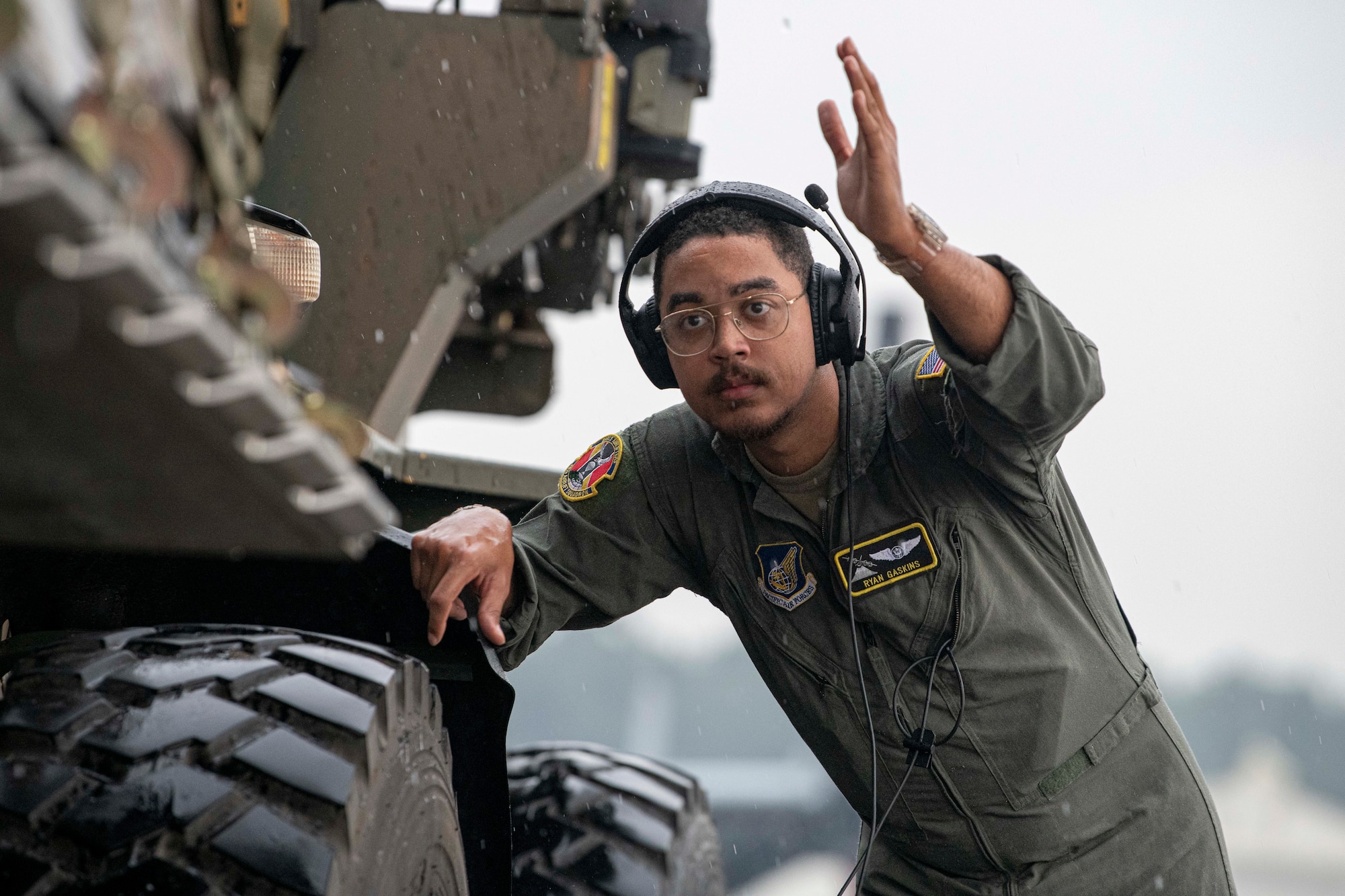 An Airman guides a 10k All-Terrain forklift carrying palletized family food packs during a foreign disaster relief operation.