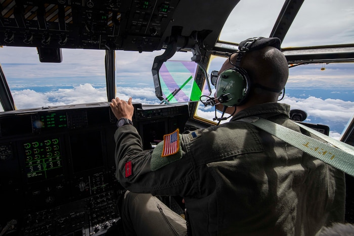 An Airman flies a C-130J Super Hercules over Philippine airspace to deliver family food packs during a foreign disaster relief operation.