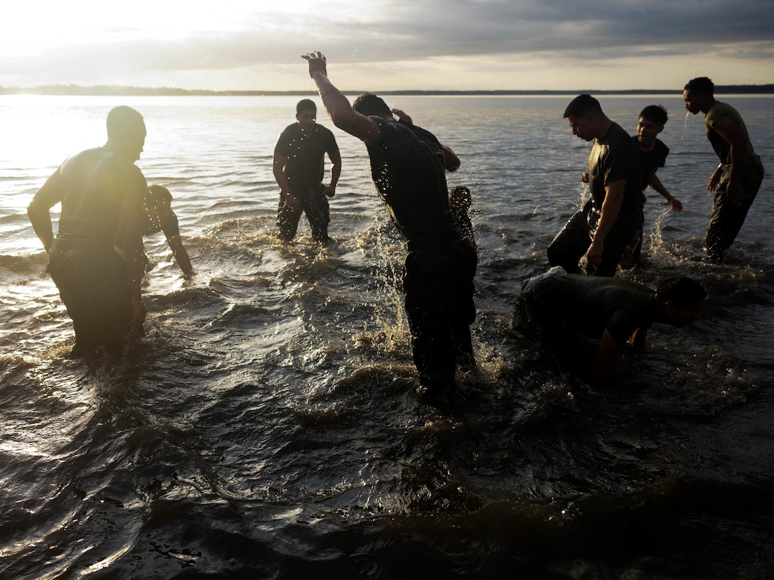 U.S. Marines with II Marine Expeditionary Force Support Battalion, II Marine Expeditionary Force Information Group, conduct burpees in the water during the II MSB squad competition at Marine Corps Base Camp Lejeune, North Carolina, Nov 7, 2025. The squad competition was held to celebrate the Marine Corps’ 250th Birthday. (U.S. Marine Corps photo by Lance Cpl. Allison White.)