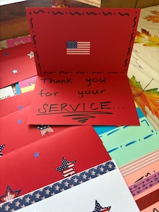 Red card opened with the words "Thank you for your service" written inside
