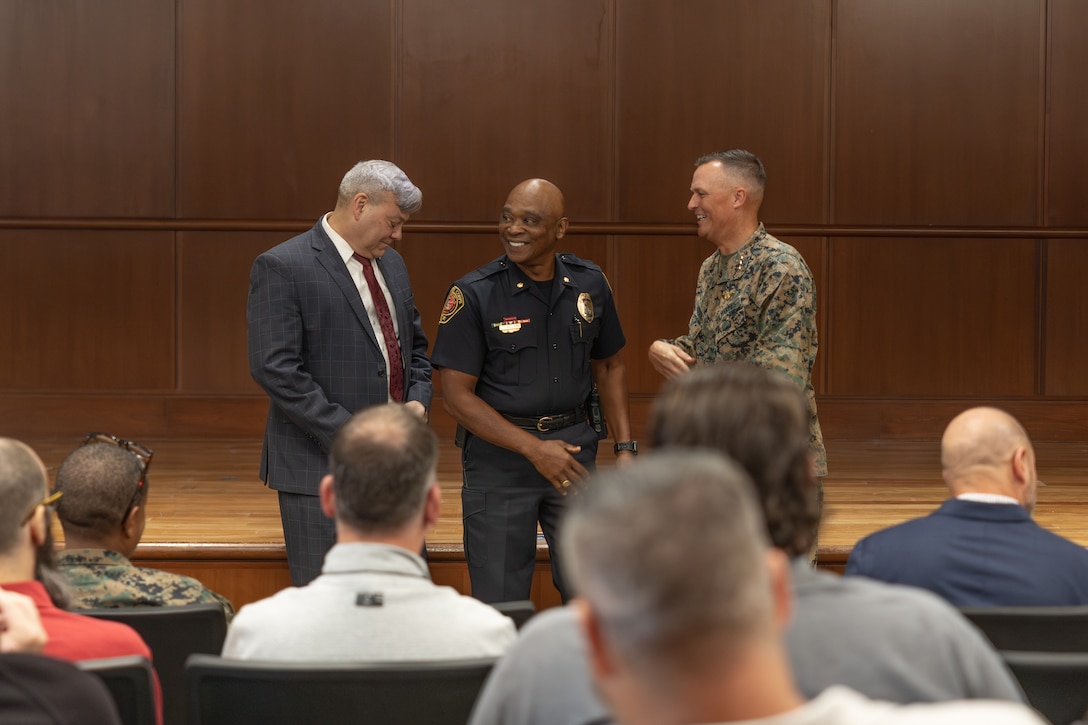 Gregg Habel, left, executive director of Marine Force Reserve and Marine Forces South, and Lt. Gen. Leonard F. Anderson IV, right, commander of Marine Force Reserve and Marine Forces South recognizes 25 years of federal service by Clearance Gillard, deputy chief police with Marine Corps Support Facility New Orleans’ Provost Marshalls Office during a town hall meeting at Marine Corps Support Facility New Orleans, Nov. 20, 2025. The town hall meeting addressed improvements to civilian work life at Marine Corps Support Facility New Orleans and future operations within Marine Forces Reserve and Marine Forces South. (U.S. Marine Corps photo by Lance Cpl. Carlina Holland)