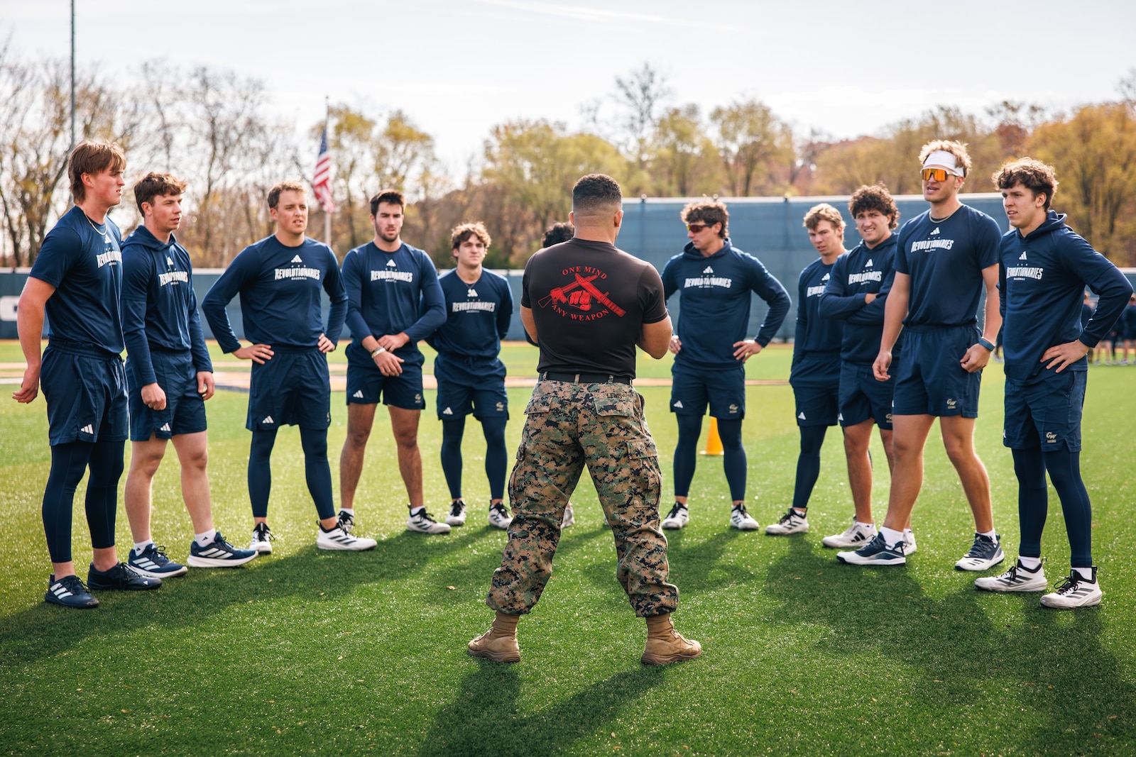 U.S. Marine Corps Staff Sgt. John Lewis, a Martial Arts Instructor Trainer with the Martial Arts and Fitness Center of Excellence, briefs a group of players with the George Washington University baseball team prior to a physical training event at Tucker Field in Arlington, Virginia, Nov. 14, 2025. Marines with the MAFCE challenged the GWU baseball team in a physical training event to inspire and train in team building skills in order to develop a greater sense of unit leadership, further uniting the team. (U.S. Marine Corps photo by Cpl. Braydon Rogers)