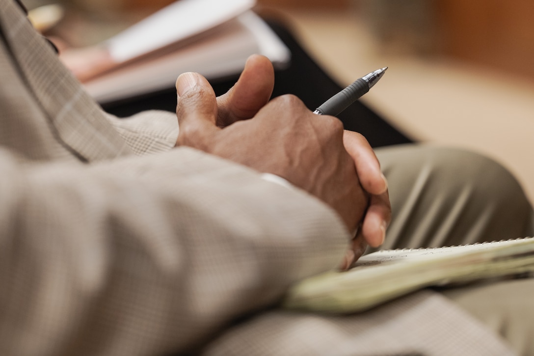 A federal employee takes notes during a town hall meeting held at the Marine Corps Support Facility New Orleans, Nov. 20, 2025. This town hall meeting addressed improvements to civilian work life at Marine Corps Support Facility New Orleans and future operations within Marine Forces Reserve and Marine Forces South. (U.S. Marine Corps photo by Lance Cpl. Van Hoang)