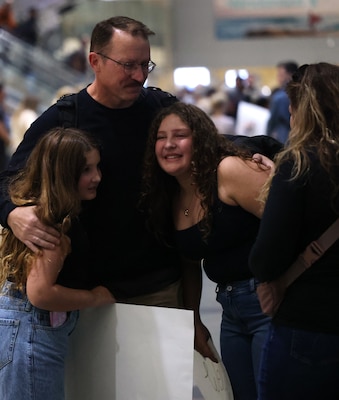SAN DIEGO (Oct. 16, 2025) – Capt. Jonas Carmichael, officer-in-charge of Navy Expeditionary Medical Unit 10 Gulf (EMU-10G), is welcomed home by his family at San Diego International Airport. The EMU's deployment reinforced the importance of building bridges with supporting units to accomplish their mission, according to Carmichael. Carmichael also noted the unit’s work supporting “Mercy Flights” for Iraqi Security Forces combating ISIS and developing combined training programs. (U.S. Navy photo by Arsenio R. Cortez Jr.)