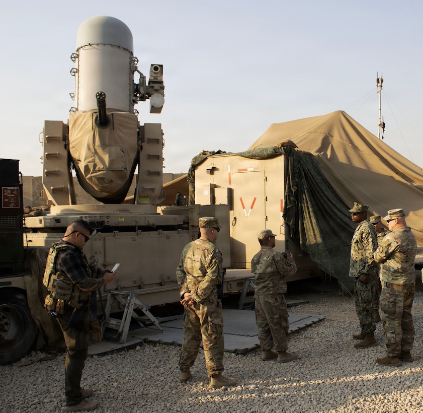 U.S. Navy Fleet Master Chief Lateef Compton, senior enlisted leader of U.S. Central Command and U.S. Army Command Sgt. Maj. Robert Preusser, senior enlisted leader of Combined Joint Task Force - Operation Inherent Resolve (CJTF-OIR), are briefed on the Counter Rocket, Artillery and Mortar (C-RAM) system, by Task Force Defender, in Erbil, Iraq, Nov. 6, 2025. The C-RAM system defends coalition bases from aerial threats and contributes to the Combined Joint Task Force – Operation Inherent Resolve mission to ensure the continued military defeat of ISIS. (British Army photo by Maj. Miles Cuff)