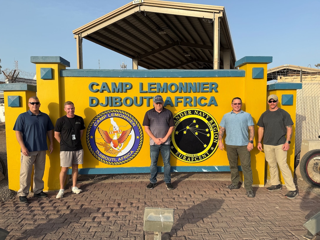 U.S. Army Lt. Col. Daniel Cooper, 2nd Lt. Samuel Feldman, Lt. Col. Timothy Crabtree, Maj. Jason Spayd and U.S. Air Force Master Sgt. Dylan Rhodes in front of the Camp Lemonnier sign in Djibouti, Africa in August 2025.