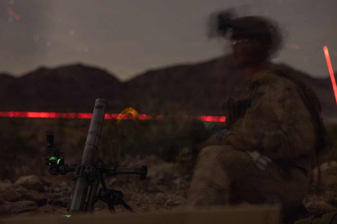 A U.S. Marine with Weapons Company, 3rd Battalion, 7th Marine Regiment, 1st Marine Division, prepares to fire an M224 60 mm mortar system during Range 400 at Marine Corps Air-Ground Combat Center Twentynine Palms, California, Oct. 25, 2025. Range 400 is a dynamic live-fire range that allows companies the ability to rehearse tactics and procedures for attacking fortified areas. (U.S. Marine Corps photo by Cpl. Earik Barton)