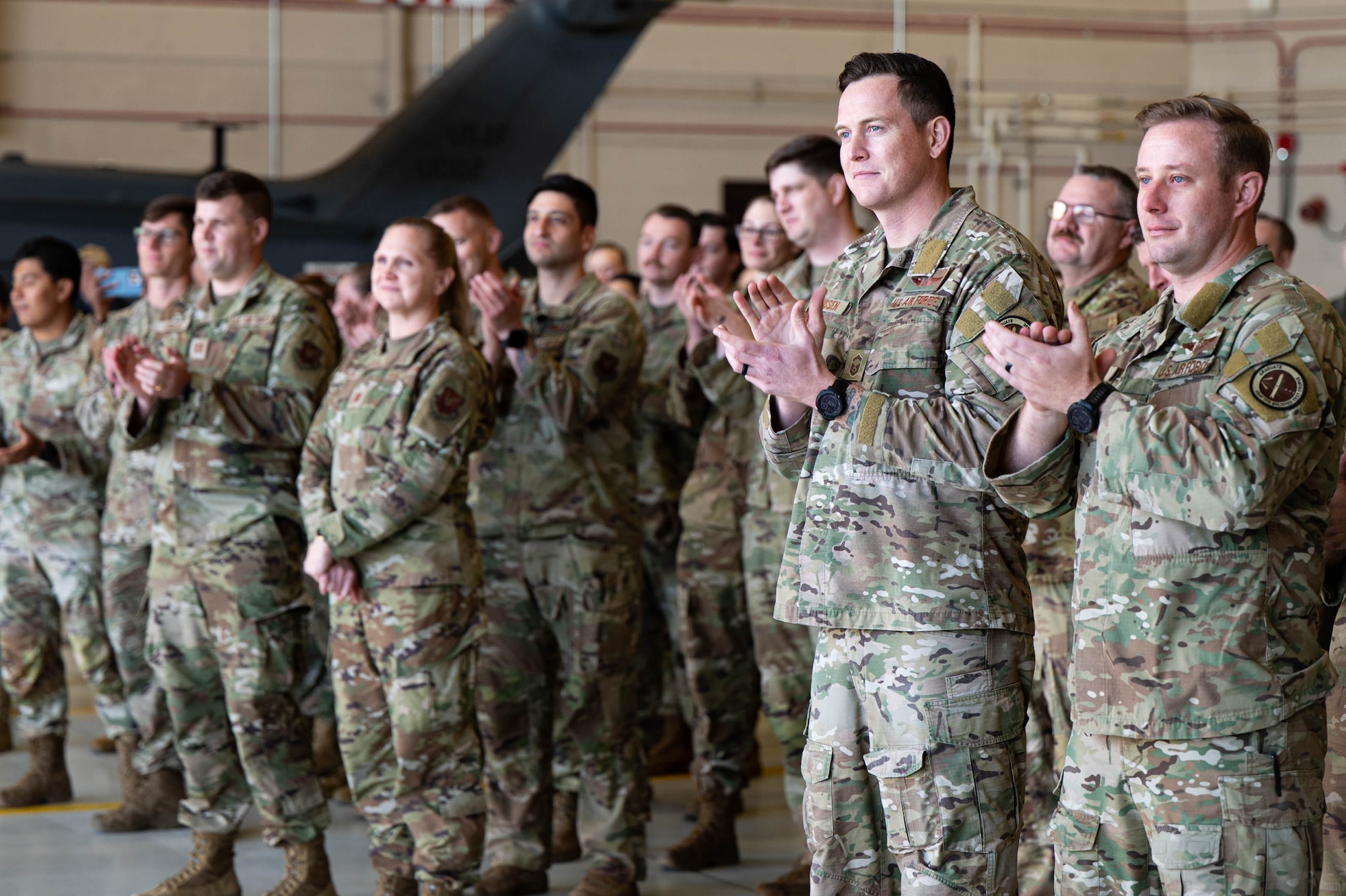 A group of uniformed personnel clap.