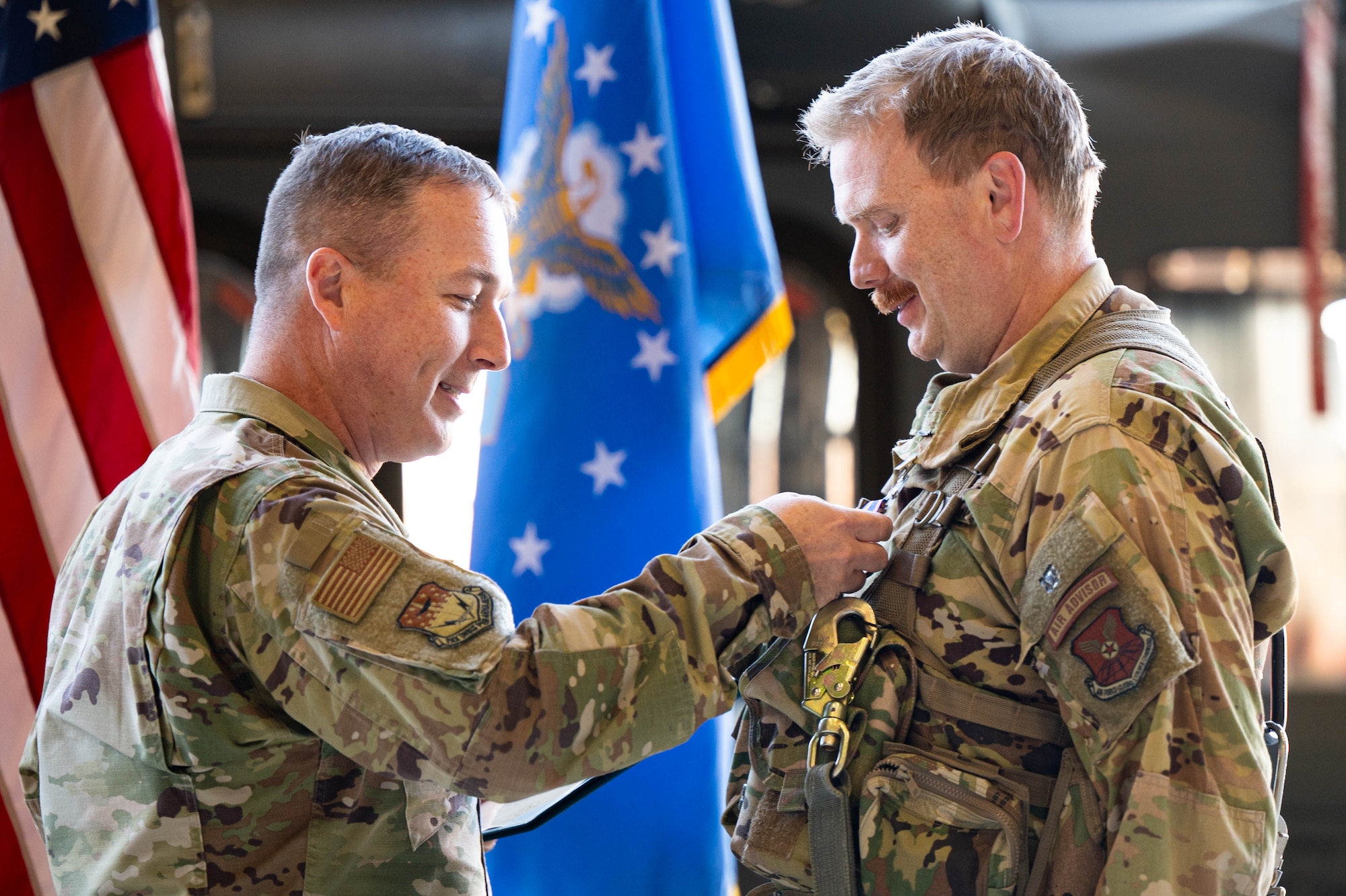 A man in uniform pins a medal on another man in uniform.