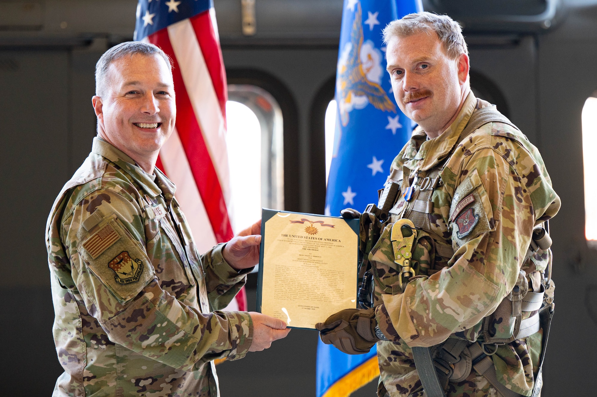Two men in uniform hold a certificate together.