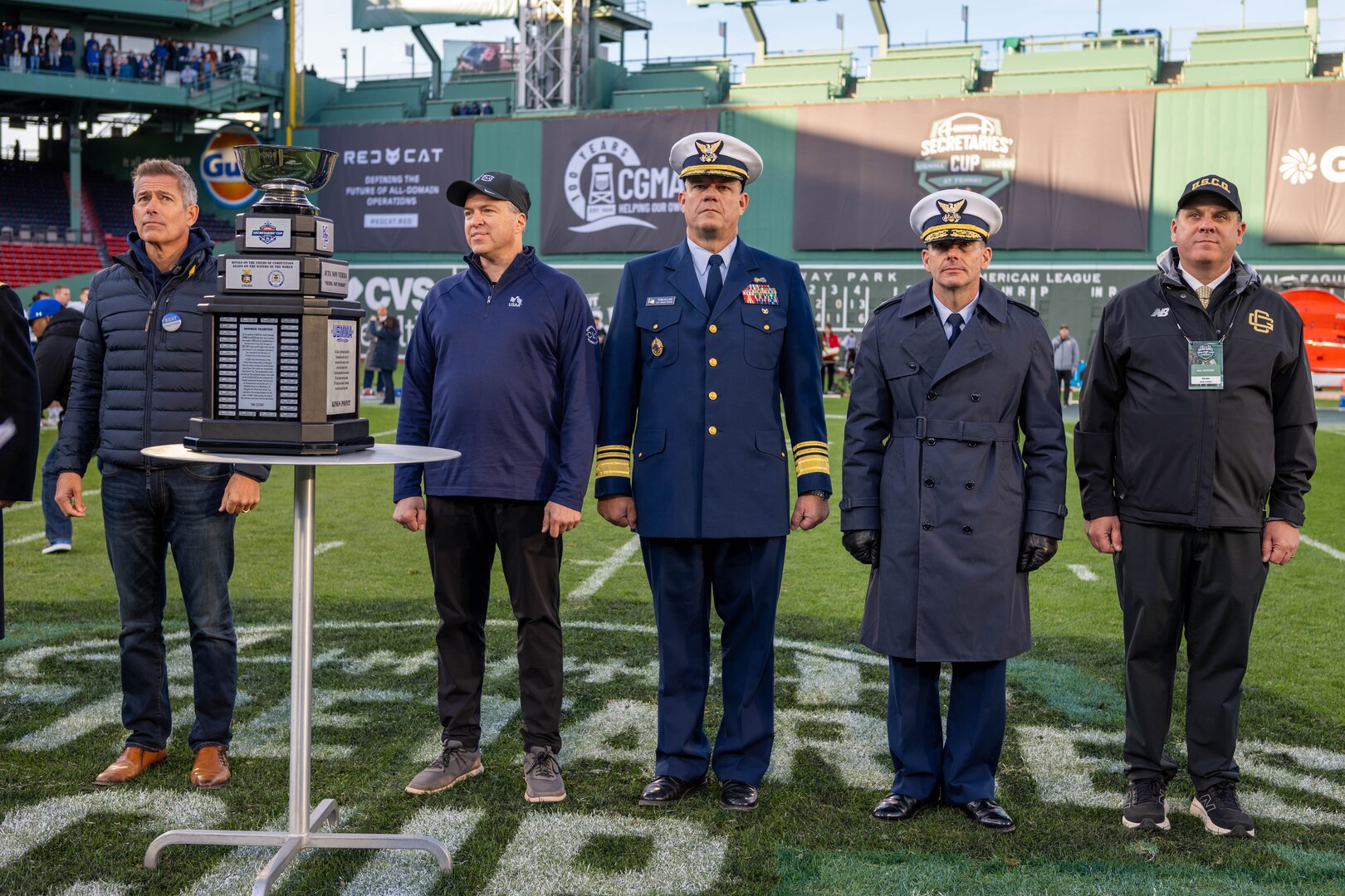 Secretary of Transportation Sean P. Duffy (left), Vice Commandant of the U.S. Coast Guard Adm. Tom Allan (middle to right), U.S. Coast Guard Academy (USCGA) Superintendent Rear Adm. Gregory Rothrock, and USCGA Director of Athletics Dr. Dan Rose pose for a photo during the 54th Secretaries' Cup at Fenway Park, Boston, Nov. 15, 2025. In 2003, "Secretary's Cup" was pluralized when the U.S. Coast Guard moved to the Department of Homeland Security. (U.S. Coast Guard photo by Petty Officer Second Class Janessa Warschkow.)