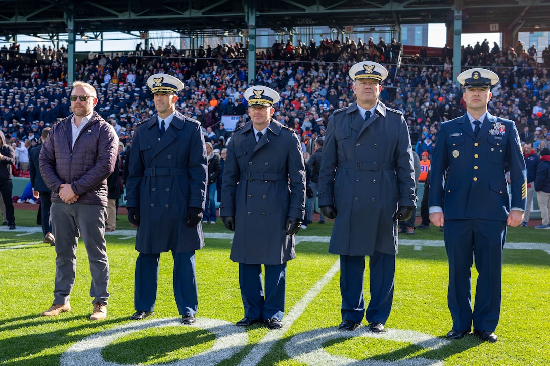 Senior Advisor to the Secretary for the Coast Guard (SASCG) Mr. Sean Plankey (left to right), Capt. Aaron Casavant, U.S. Coast Guard Academy (USCGA) Superintendent Rear Adm. Gregory Rothrock, and Vice Commandant of the U.S. Coast Guard Adm. Tom Allan, stand on the field prior to kickoff at the 54th Secretaries’ Cup game at Fenway Park, Boston, Nov. 15, 2025. In 2003, “Secretary’s Cup” was pluralized when the U.S. Coast Guard moved to DHS. (U.S. Coast Guard photo by Petty Officer Second Class Janessa Warshckow.)