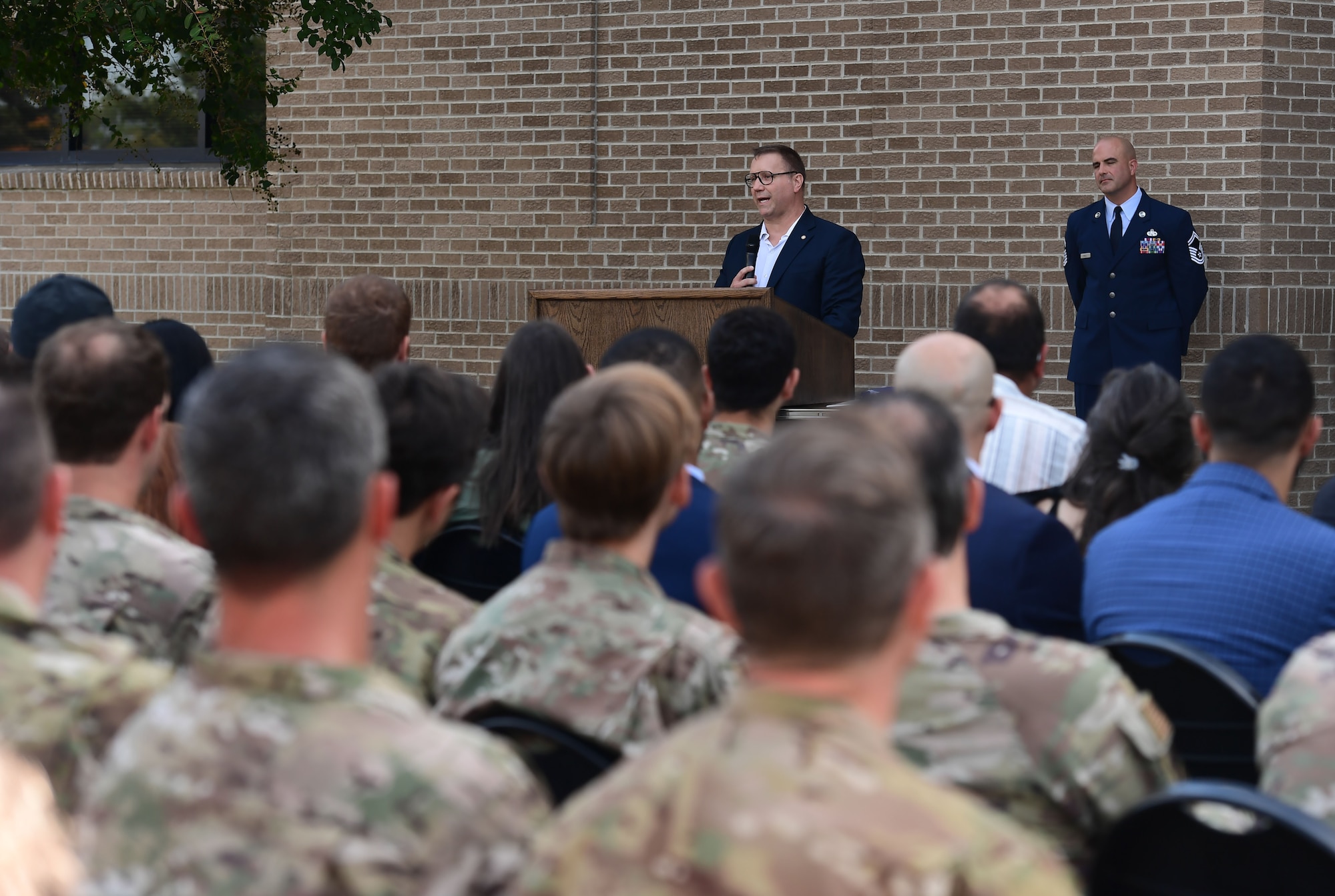 A man speaks to a group of people from behind a podium