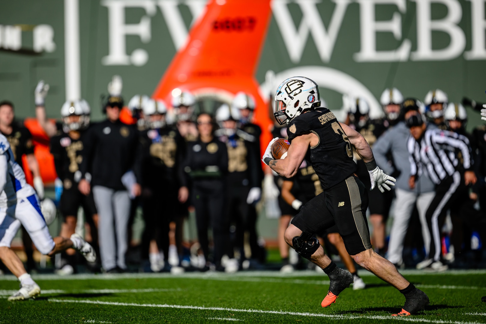 U.S. Coast Guard Academy football player runs the ball during a play against the U.S. Merchant Marine Academy at Fenway Park, Boston, Nov. 15, 2025. The location of the 54th Secretaries’ Cup is significant for being in a Major League stadium in the heart of New England, the birthplace of the U.S. Coast Guard. (U.S. Coast Guard courtesy photo by David Lau.)