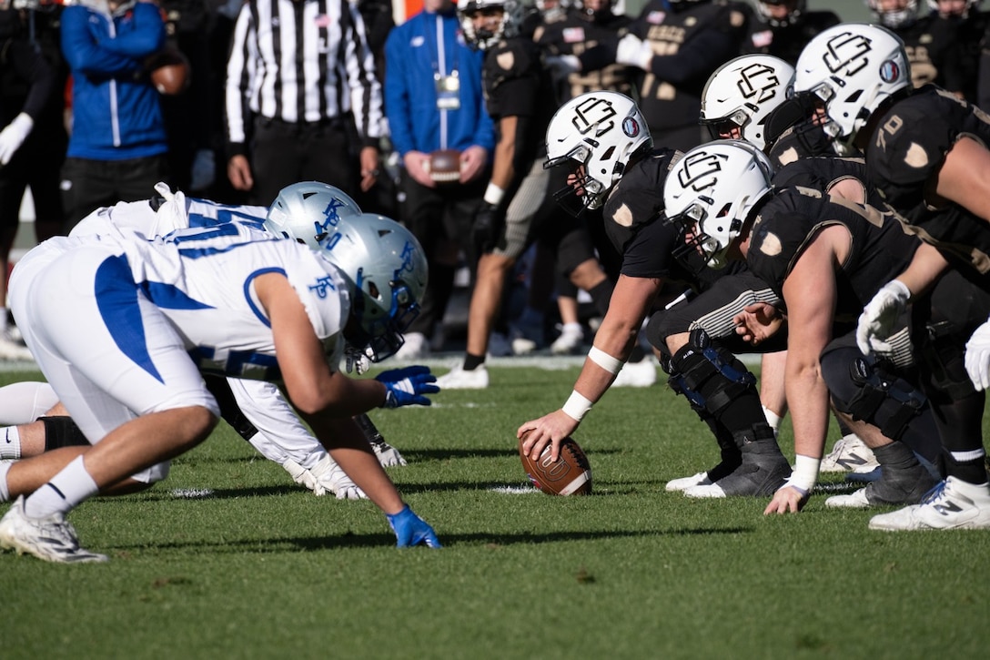 U.S. Coast Guard Academy football players prepare to execute a play during the 54th Secretaries’ Cup at Fenway Park, Boston, Nov. 15, 2025. In 2003, “Secretary’s Cup” was pluralized when the U.S. Coast Guard moved to the Department of Homeland Security. (U.S. Coast Guard photo by Petty Officer Third Class Leo Avila.)