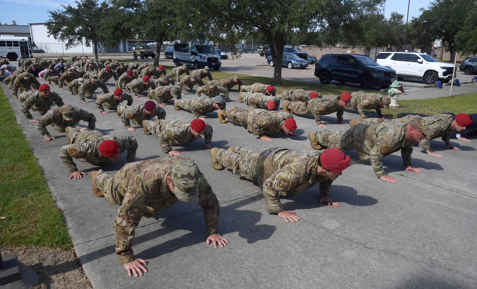A group of men wearing military uniforms participate in push-ups