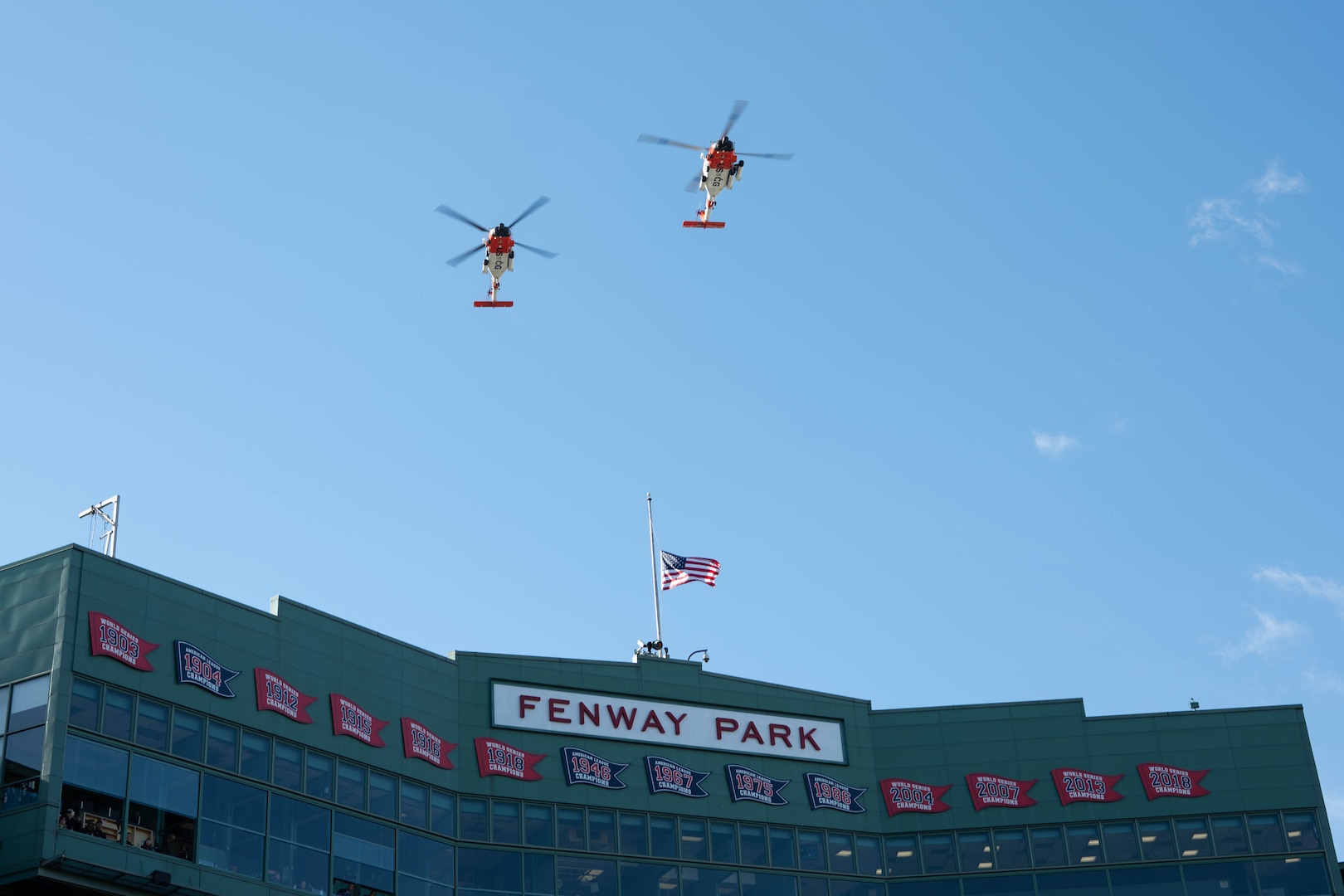 Two U.S. Coast Guard Air Station Cape Cod MH-60 Jayhawk aircrews flyover the stadium before the start of the 54th Secretaries' Cup at Fenway Park, Boston, Nov. 15, 2025. The location of the game is significant for being in a Major League stadium in the heart of New England, the birthplace of the U.S. Coast Guard. (U.S. Coast Guard photo by Petty Officer Second Class Janessa Warschkow.)