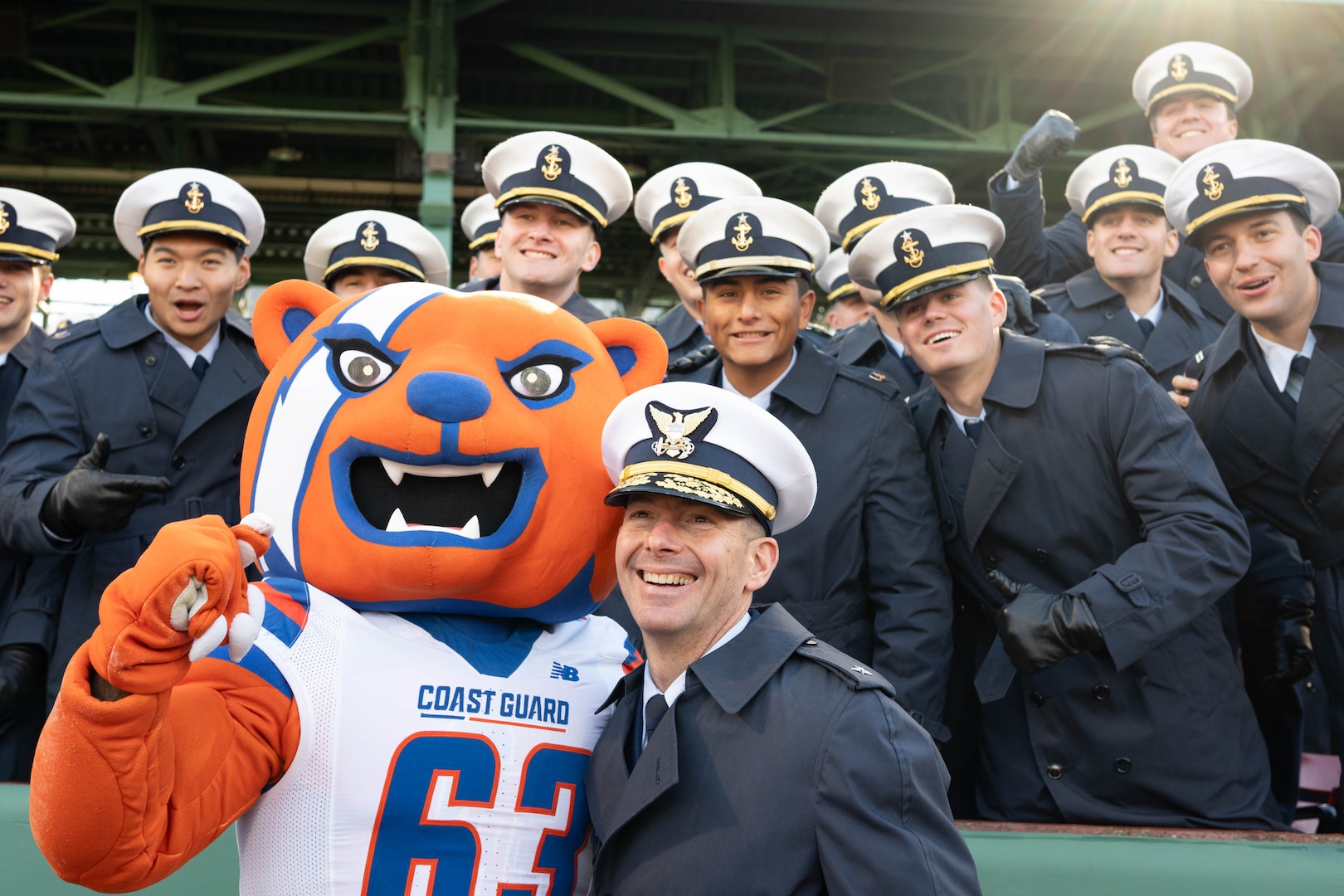 U.S. Coast Guard Academy (USCGA) Superintendent Rear Adm. Gregory Rothrock pose for a photo with cadets before the start of the 54th Secretaries’ Cup between USCGA and the U.S. Merchant Marine Academy (USMMA) at Fenway Park, Boston, Nov. 15, 2025. USCGA won last year’s Secretaries’ Cup, ending the game with a 42-21 score against USMMA. (U.S. Coast Guard photo by Petty Officer Second Class Janessa Warshckow.)