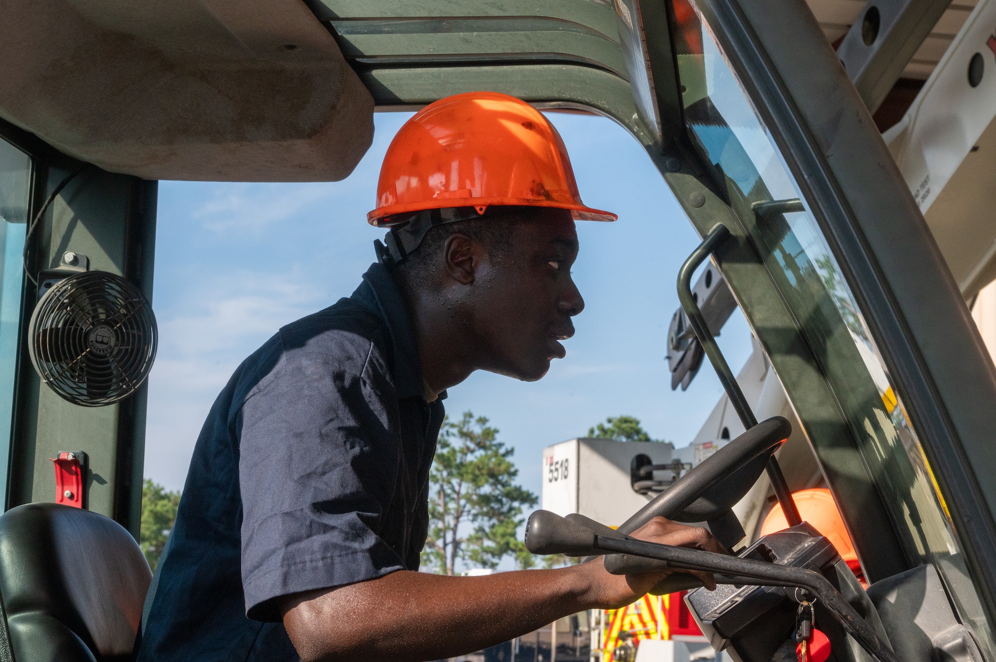 A man concentrates as he drives a forklift.