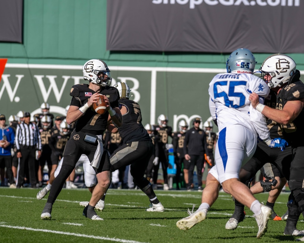 U.S. Coast Guard Academy football players execute a play against U.S. Merchant Marine football players during the 54th Secretaries' Cup at Fenway Park, Boston, Nov. 15, 2025. Fenway Park hosted the 54th Secretaries' Cup, giving both service academies a national stage to showcase their hard work and dedication. (U.S. Coast Guard photo by Petty Officer Third Class Leo Avila.)