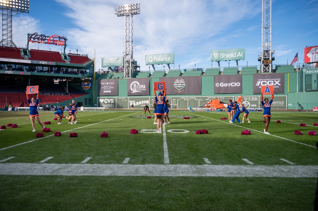 U.S. Coast Guard Academy cheerleaders perform their full routine during halftime at the 54th Secretaries' Cup in Fenway Park, Boston, Nov. 15, 2025. The location of the 54th Secretaries' Cup is significant for being in a Major League stadium in the heart of New England, the birthplace of the U.S. Coast Guard. (U.S. Coast Guard photo by Petty Officer Third Class Leo Avila.)