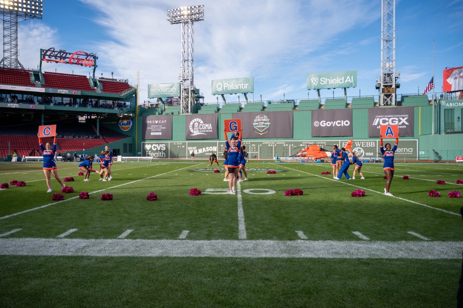 U.S. Coast Guard Academy cheerleaders perform their full routine during halftime at the 54th Secretaries' Cup in Fenway Park, Boston, Nov. 15, 2025. The location of the 54th Secretaries' Cup is significant for being in a Major League stadium in the heart of New England, the birthplace of the U.S. Coast Guard. (U.S. Coast Guard photo by Petty Officer Third Class Leo Avila.)