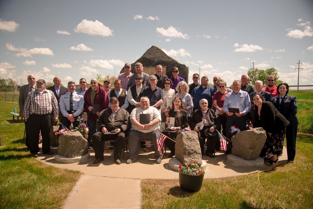 Individuals stand in a group outside and pose for photo. Courtesy.