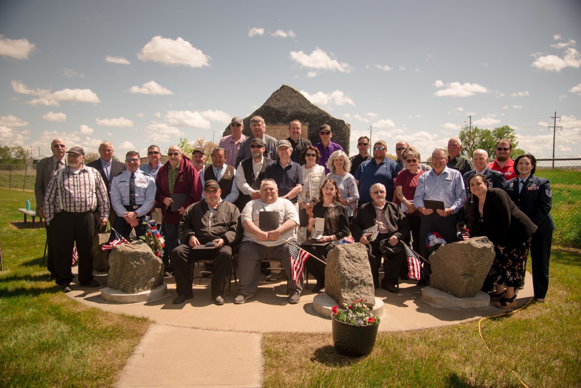 Individuals stand in a group outside and pose for photo. Courtesy.
