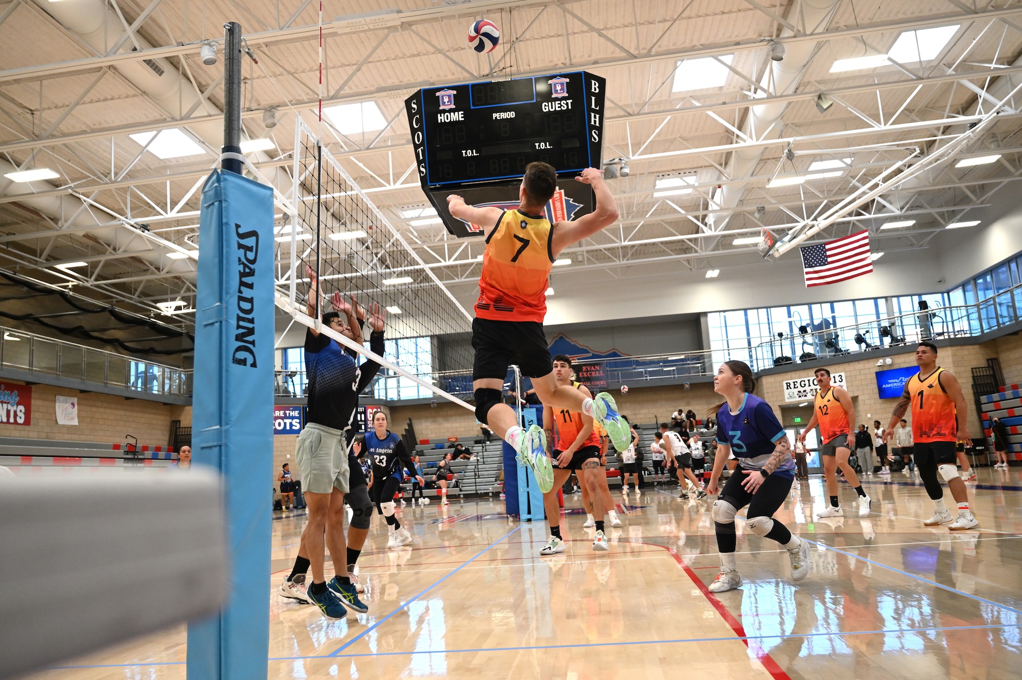 This image portrays Hill AFB's volleyball team playing against other bases at an Air Force Varsity Volleyball League tournament.
