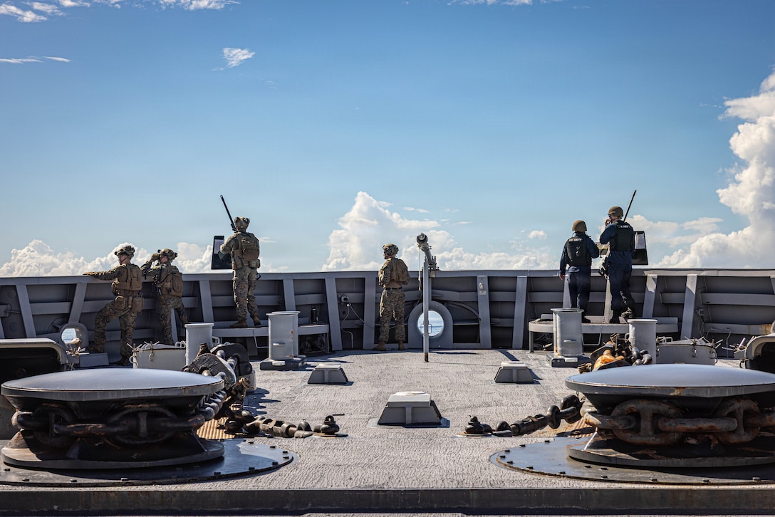 U.S. Marines with India Company, Battalion Landing Team 3/6, 22nd Marine Expeditionary Unit (Special Operations Capable), and Sailors assigned to San Antonio-class amphibious transport dock USS Fort Lauderdale (LPD 28) observe the operating area during a strait transit while underway in the Caribbean Sea, Nov. 18, 2025. U.S. military forces are deployed to the Caribbean in support of the U.S. Southern Command mission, Department of War-directed operations, and the president's priorities to disrupt illicit drug trafficking and protect the homeland. (U.S. Marine Corps photo)