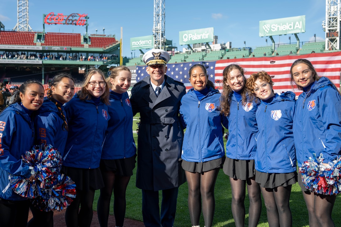 U.S Coast Guard Academy (USCGA) Superintendent Rear Adm. Gregory Rothrock (middle) and USCGA cheer team pose for a photo on the football field at Fenway Park, Boston, Nov. 15, 2025. USCGA won last year’s Secretaries’ Cup, ending the game with a 42-21 score against USMMA. (U.S. Coast Guard photo by Petty Officer Second Class Janessa Warshckow.)