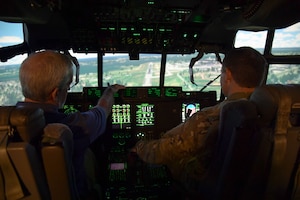 Two men operate a flight simulator