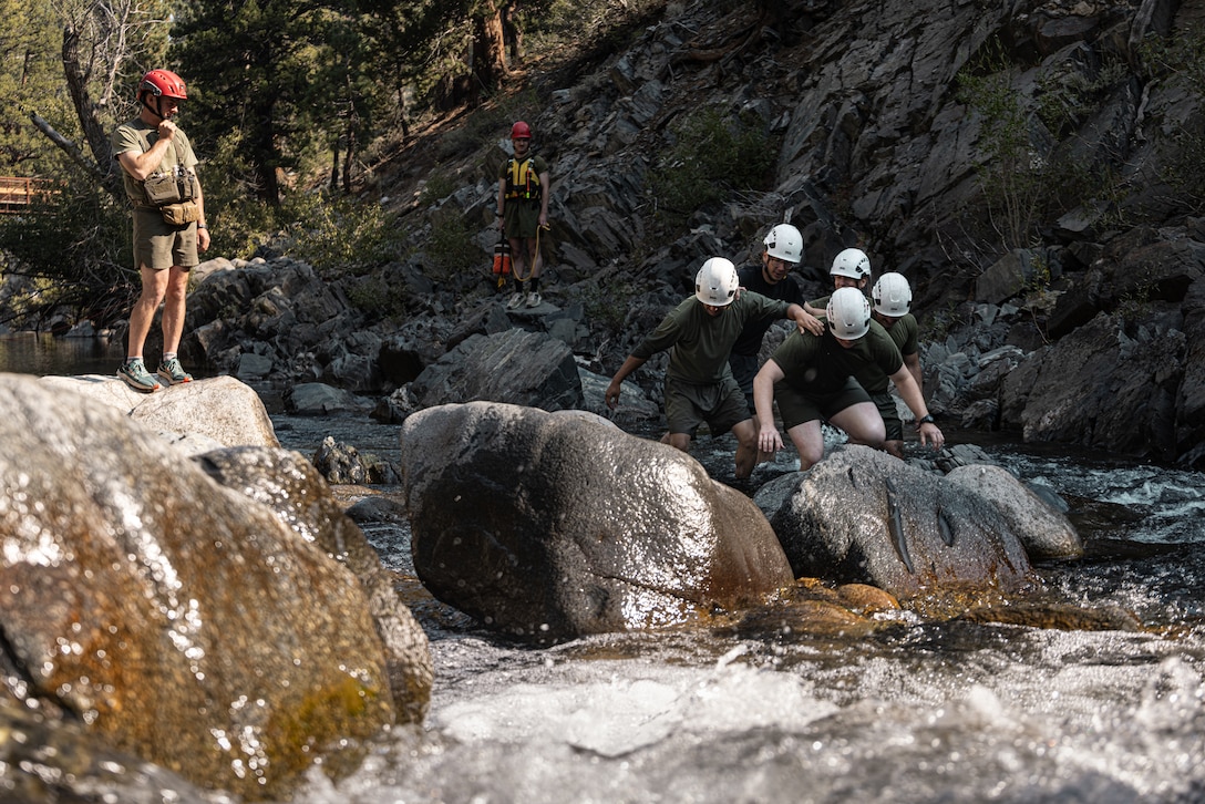 U.S. service members conduct team stream crossing exercises as part of Mountain Medicine 3-25 at Marine Corps Mountain Warfare Training Center, Bridgeport, California, Sep. 7, 2025. MMED challenges service members with various medical and technical problems common to mountainous environments in preparation for future conflicts in austere terrain. (U.S. Marine Corps photo by Lance Cpl. Enge You)
