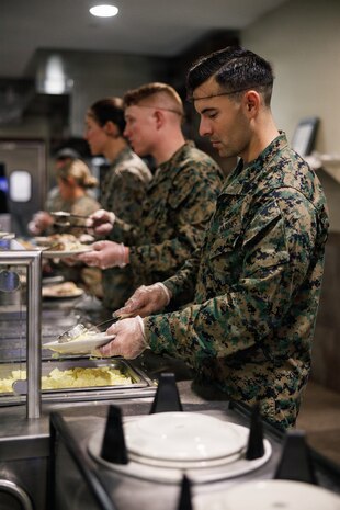 U.S. Marine Corps Gunnery Sgt. Edwin Omanahernandez, the staff noncommissioned officer in charge of Company D, Basic Officer Course 4-25, The Basic School, serves food during the Warrior’s Breakfast at TBS, Marine Corps Base Quantico, Virginia, Nov. 20, 2025. The Warrior’s breakfast follows the Warfighting Field Exercise, which serves as the culminating event at TBS, evaluating students’ proficiency in decision-making, small-unit tactics, and leadership as they operate under sustained physical and mental pressure in a realistic warfighting scenario. (U.S. Marine Corps photo by Cpl. Joshua Barker)