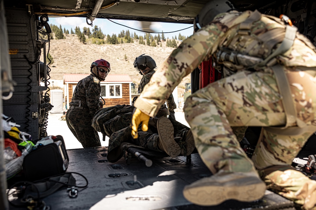 U.S. Navy Lt. Kevin Lawrence, an Iowa native, instructor with Marine Corps Mountain Warfare Training Center, Marine Air Ground Task Force Training Command, left, and U.S. Army Soldiers conduct casualty evacuation exercises out of an HH-60M Black Hawk helicopter as part of Mountain Medicine 3-25 at MCMWTC, Bridgeport, California, Sept. 13, 2025. MMED challenges service member with various medical and technical problems common to mountainous environments in preparation for any potential future conflicts in austere terrain. (U.S. Marine Corps photo by Lance Cpl. Enge You)