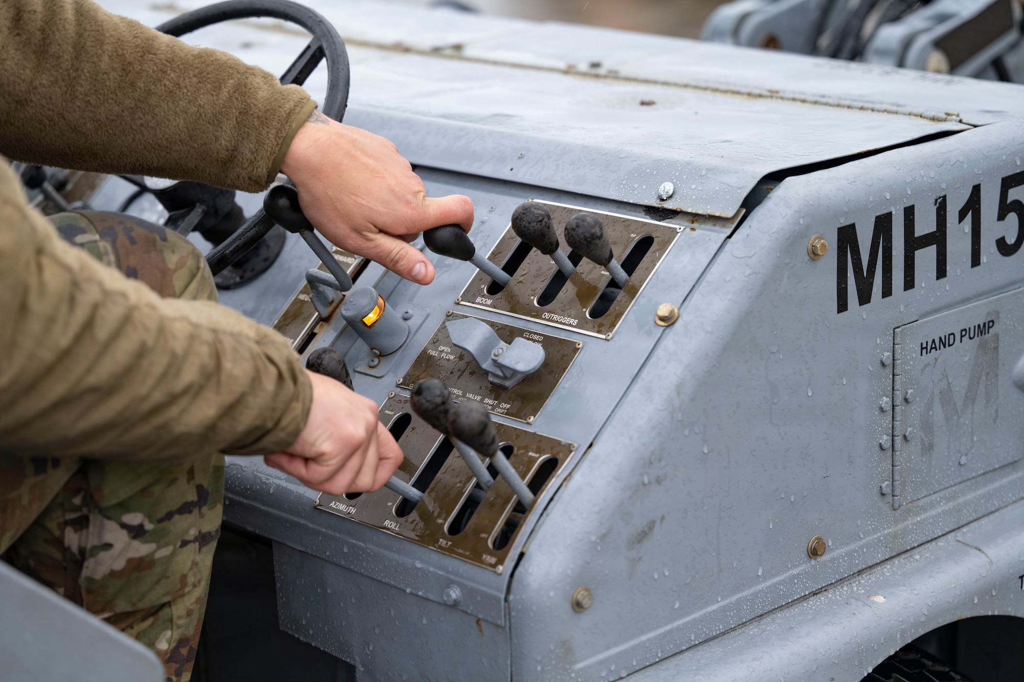 Airmen prepare to load a large weapon onto a B-1 Lancer outside on the flightline