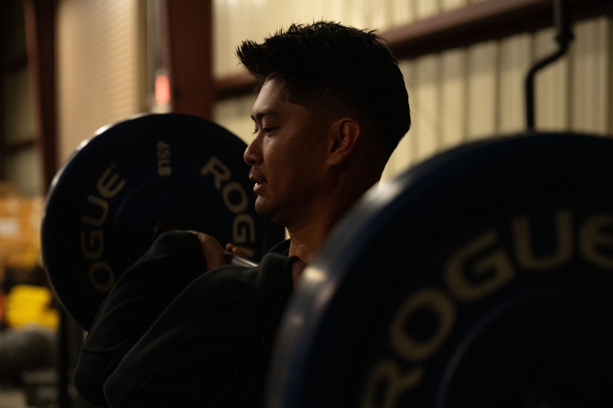 U.S. Air Force Senior Airman Nicholas San Gabriel, 355th Civil Engineer Squadron electrical journeyman, performs a front squat during the Salute in Motion memorial at Davis-Monthan Air Force Base, Arizona, Nov. 21, 2025. Explosive ordnance disposal Airmen hosted Salute in Motion, an annual memorial honoring EOD service members who lost their lives in the line of duty. (U.S. Air Force photo by Airman 1st Class Jaden Kidd)