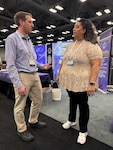 Mattthew Borsinger, left, and Danielle Williams, right, discuss the Defense Logistics Agency Enterprise Rotation Program at the Defense Manufacturing Conference in Austin, Texas, Dec. 2, 2024. (DLA photo by Nutan Chada)