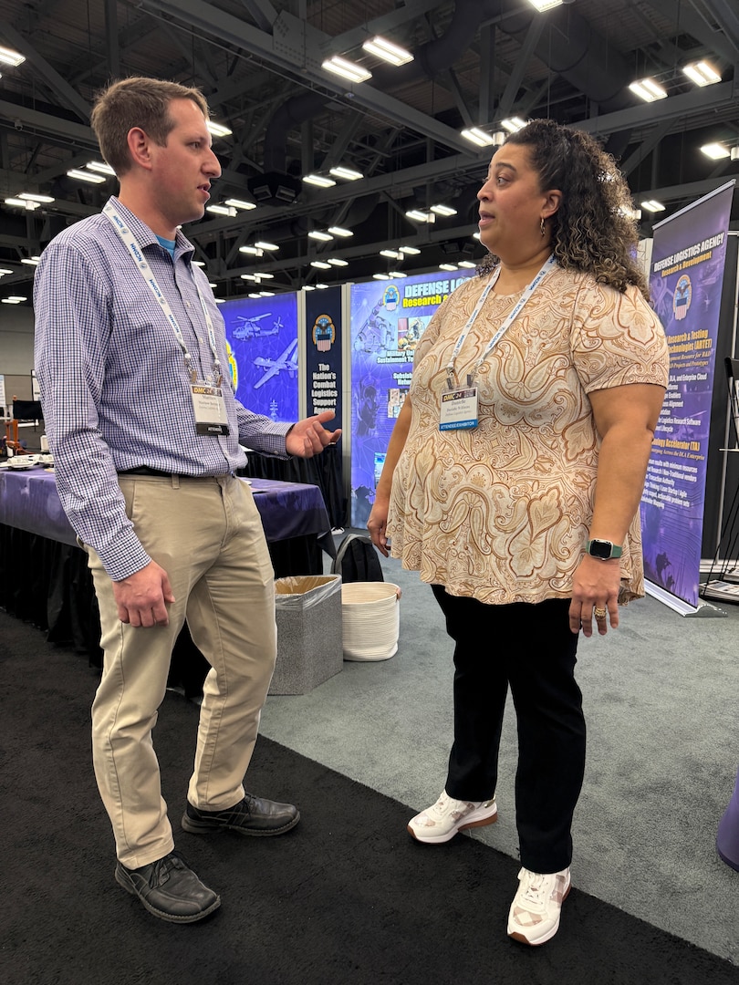Mattthew Borsinger, left, and Danielle Williams, right, discuss the Defense Logistics Agency Enterprise Rotation Program at the Defense Manufacturing Conference in Austin, Texas, Dec. 2, 2024. (DLA photo by Nutan Chada)