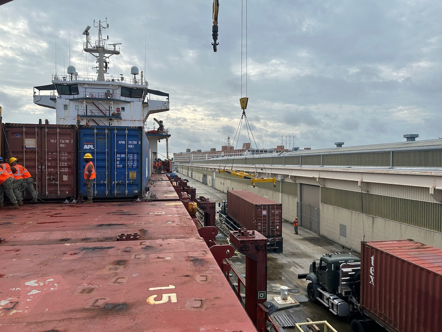 A shipping vessel being loaded while at port.