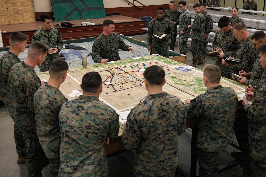 U.S. Marine Corps Capt. Zachary Toney, a staff platoon commander and infantry officer with The Basic School, Training Command, center, issues a combat order to students with Company D, Basic Officer Course 4-25, during the warfighting field exercise at TBS, Marine Corps Base Quantico, Virginia, Nov. 17, 2025. The WARFEX serves as the culminating event at TBS, evaluating students’ proficiency in decision-making, small-unit tactics, and leadership as they operate under sustained physical and mental pressure in a realistic warfighting scenario. (U.S. Marine Corps photo by Cpl. Joshua Barker)