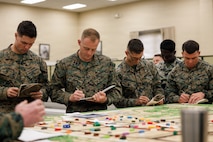 U.S. Marine Corps students with Company D, Basic Officer Course 4-25, The Basic School, Training Command, take notes during a combat mission brief during the warfighting field exercise at TBS, Marine Corps Base Quantico, Virginia, Nov. 17, 2025. The WARFEX serves as the culminating event at TBS, evaluating students’ proficiency in decision-making, small-unit tactics, and leadership as they operate under sustained physical and mental pressure in a realistic warfighting scenario. (U.S. Marine Corps photo by Cpl. Joshua Barker)