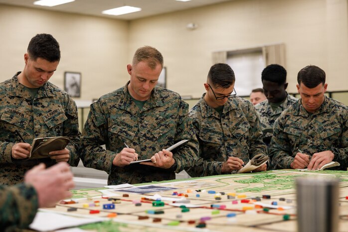 U.S. Marine Corps students with Company D, Basic Officer Course 4-25, The Basic School, Training Command, take notes during a combat mission brief during the warfighting field exercise at TBS, Marine Corps Base Quantico, Virginia, Nov. 17, 2025. The WARFEX serves as the culminating event at TBS, evaluating students’ proficiency in decision-making, small-unit tactics, and leadership as they operate under sustained physical and mental pressure in a realistic warfighting scenario. (U.S. Marine Corps photo by Cpl. Joshua Barker)