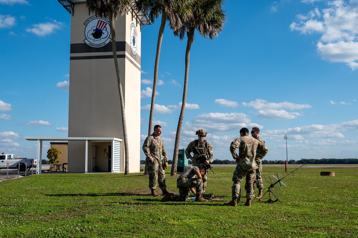 Group of men watch another work.