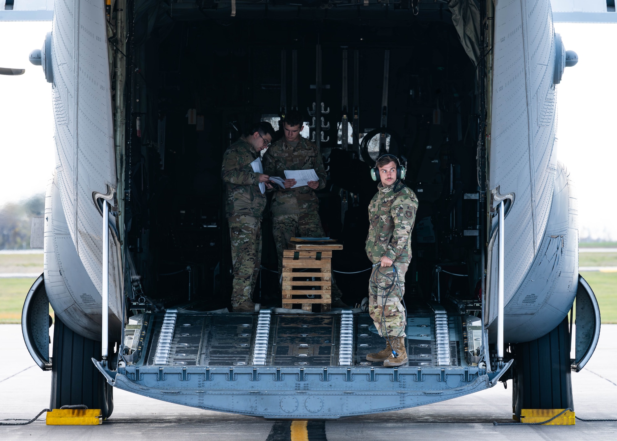 airmen stand in the back of a C-130J