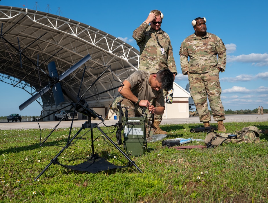 Group of men watch other man work.