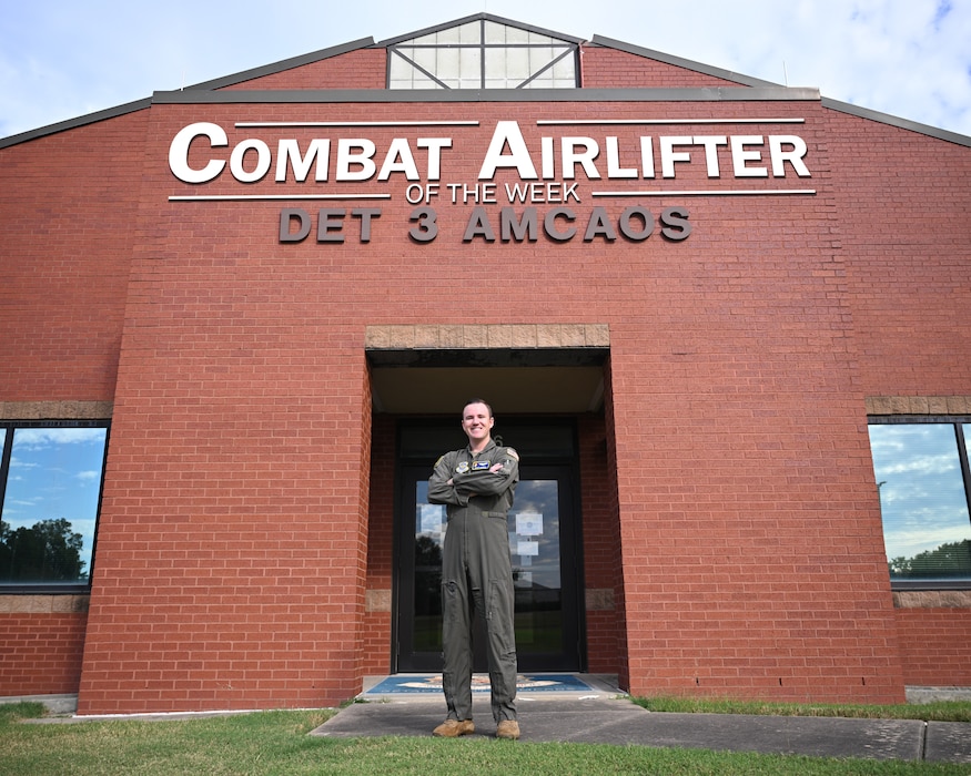 Man poses in front of building.